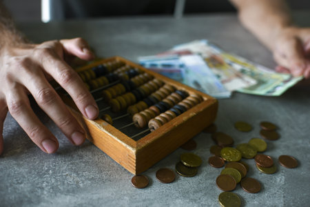 Businessman counting money with wooden abacus on table, closeupの写真素材