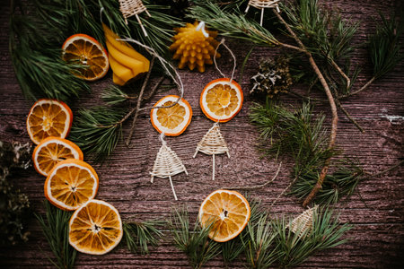 Christmas decoration with fir branches and dried orange slices on rustic wooden backgroundの写真素材