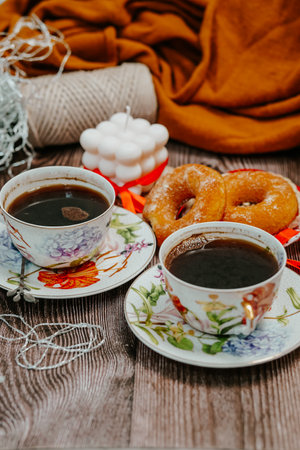 Two cups of black coffee, donuts and orange plaid on wooden backgroundの写真素材