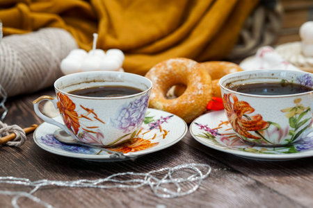 Two cups of black coffee and donuts on a wooden table.の写真素材