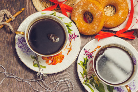 Two cups of coffee and donuts on a wooden table, top viewの写真素材