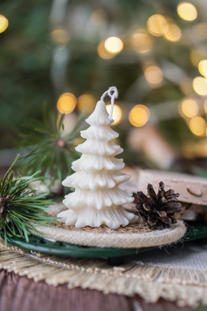 Christmas decoration with fir tree shaped soy wax candle and bokeh lights on background.の写真素材