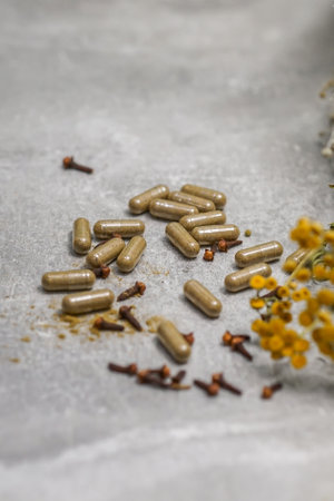 Capsules with medicinal herbs on a gray background. Selective focus.の写真素材