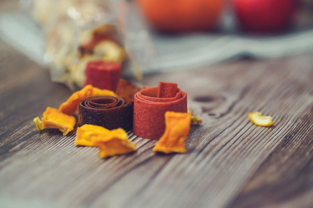 Dried orange slices and fruit leather on a wooden table. Selective focus.の写真素材