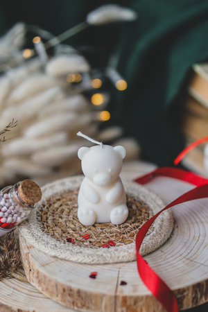 Christmas and New Year background. White bear with a candle in a wicker basket on a wooden stand.の写真素材