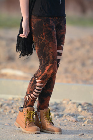Close up of legs of a young woman wearing brown leggings and bootsの写真素材