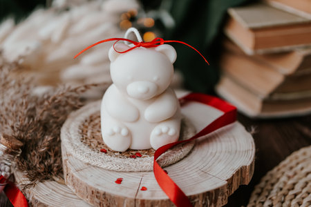 handmade soy wax candle with red ribbon on a wooden standの写真素材
