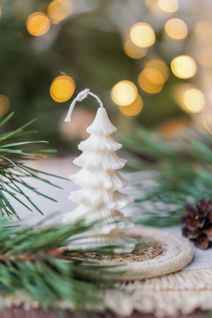 Christmas decoration with fir tree shaped soy wax candle and bokeh lights on background.の写真素材