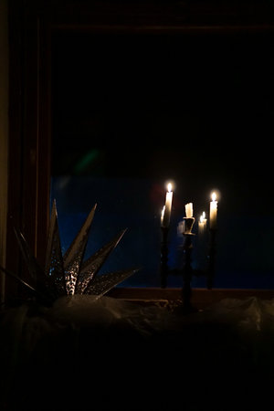 Candles in the dark with a crown of thorns on the windowsillの写真素材
