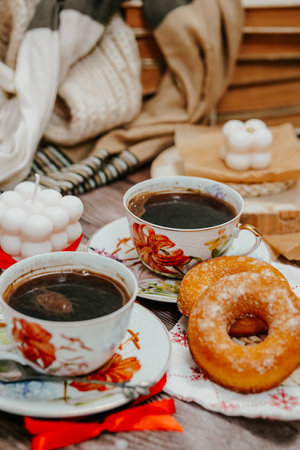 Cup of coffee, donuts and candles on the wooden backgroundの写真素材