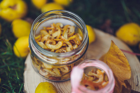Homemade canned quince in a glass jar on a wooden standの写真素材