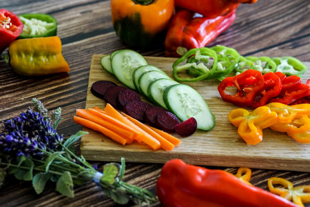 Variety of fresh vegetables on a cutting board on a wooden tableの写真素材