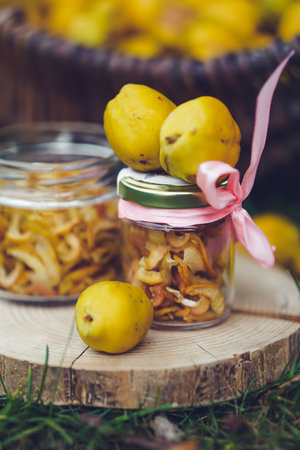 Homemade dried quinces in a glass jar on a wooden backgroundの写真素材