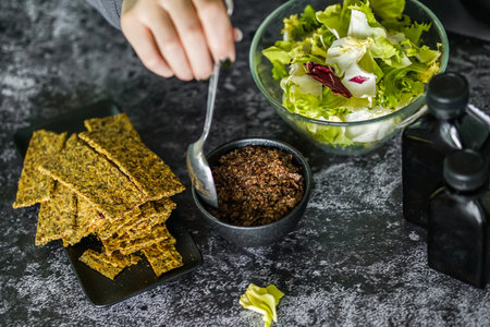 Vegetarian food. Fresh salad and crispy crackers on a black background.の写真素材