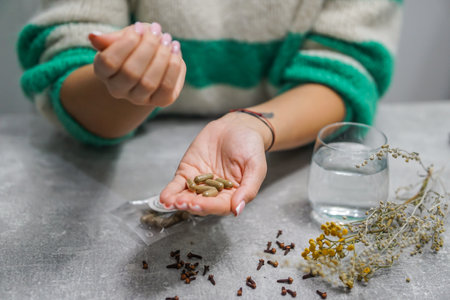 Young woman holding handful of pills on table, closeup. Alternative medicineの写真素材