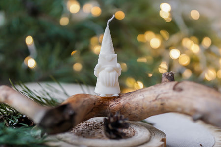 White candle on the background of a Christmas tree with bokehの写真素材