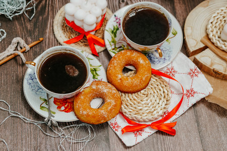 Two cups of black coffee and donuts on a wooden background.の写真素材