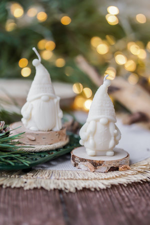 Christmas candles on a wooden background with bokeh lights in the backgroundの写真素材