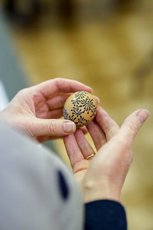 Close-up of a woman's hand painting a  easter egg using beeswaxの写真素材