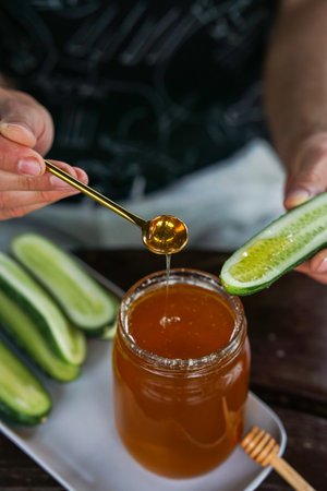 Serving fresh golden honey with crisp homegrown cucumbers â a unique and healthy flavor pairingの写真素材