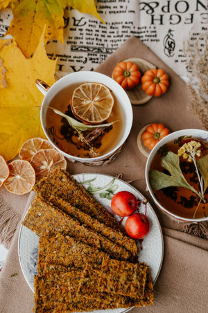 Cup of tea with lemon and cookies on the background of autumn leavesの写真素材