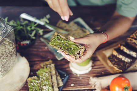 Healthy eating and dieting concept. Close up of a woman's hands holding a piece of green pestoの写真素材