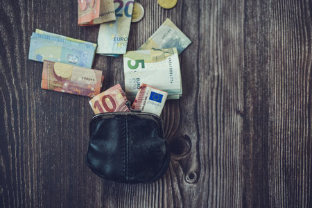 Wallet with euro banknotes on a wooden background. Selective focus.