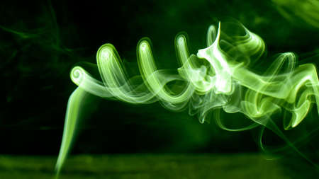 Bright green luminescent smoke revolves in a mystical vortex. Fantasy and magic photography. Great photo for your computer wallpaper or phone desktop.の写真素材