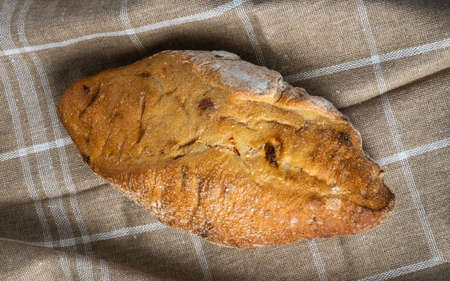 Freshly baked ciabata bread with olives just hot from the oven. Bread with flour on a brown cotton...