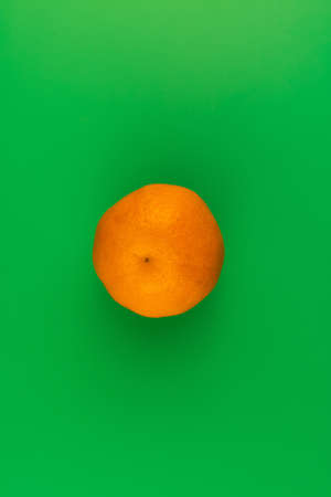 Mandarin time is here! Juicy delicious, bright orange mandarin on a trendy soft green background. Place for text. Mandarin that says it all! Gourmet photo. The background image is stylish. Minimalism.の写真素材