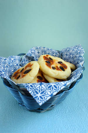 Cheese caky with raisins on blue basket on blue backgroundの写真素材
