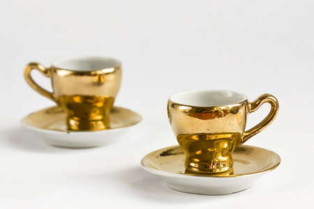 Golden coffee cups on white backgroundの写真素材