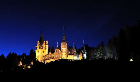 Peles castle in Romania by night. The Peles castle from Romania isolated in night time near the forest.のeditorial素材