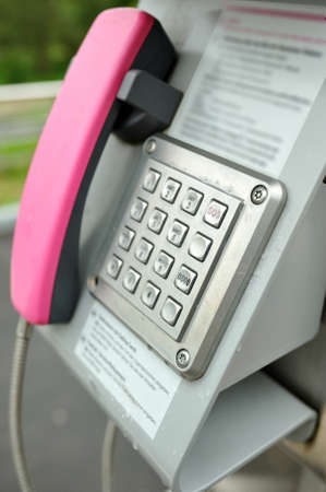 Emergency phone device. Pink phone for emergency calls from train station near the city.