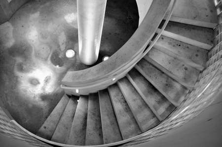 Going to underground. Way down at the underground parking on stairs in black and white.