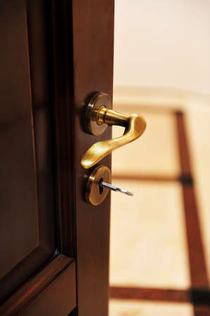 Golden door handle. Closeup view of a golden handle of the room door.の写真素材