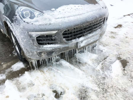 Frozen car in winter season. Luxury Porsche sport car parked, covered by ice in winter season.の写真素材