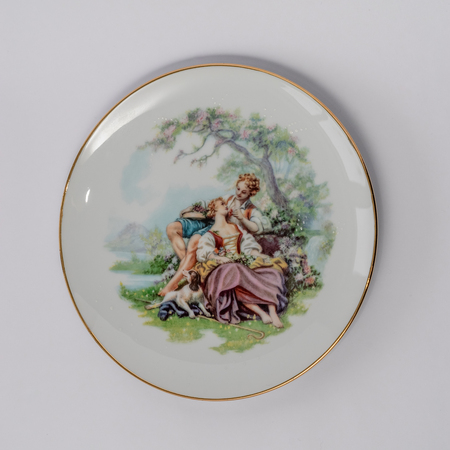 Vintage white plate on which couple of lovers are depicted.の写真素材