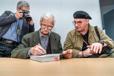 VILNIUS, LITHUANIA - FEBRUARY 22, 2019: The international Vilnius Book Fair. Henrikas Gudavicius (in the middle), naturalist, publicist, ecologist of the National Park (Southern Lithuania), A.Aleksandravicius (right). They are photographed by poet Vl.Brazのeditorial素材
