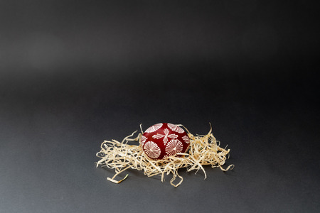 Easter egg in geometric pattern. On black background, with copy space for text