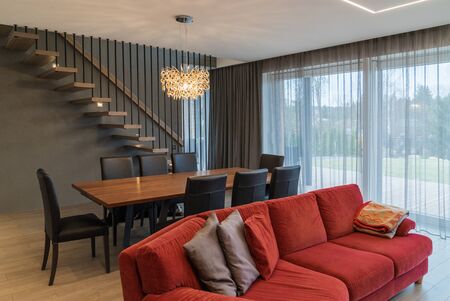 Dining area and living room. Cozy home, window, lamp, and staircase.