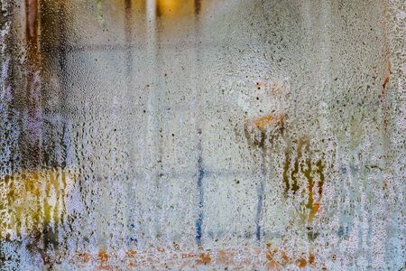 Water droplets on window glass. An iron grille for protection Abstract image.