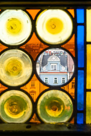 Panorama of Krakow's Old Town through the colorful stained glass window of the Town Hall Tower. In transparent Circle - tenement house "Kamienica Pod Jagniemi"の写真素材