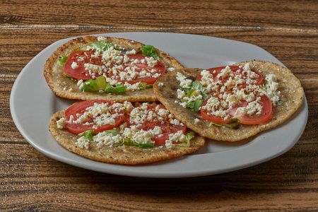 Mexican food. Gordita covered with lettuce, tomato, cheese and spicy food.の写真素材