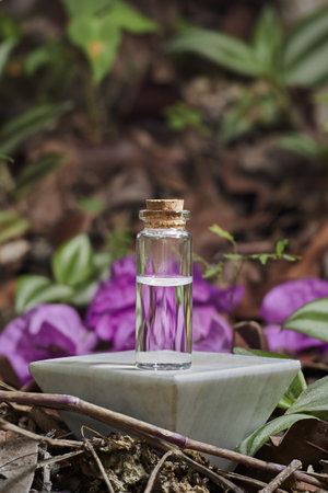 Small Glass Bottle with Liquid and Cork Stopper on Stone Tile Surface