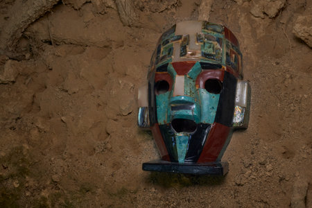 Colorful Ancient Mosaic Mask Unearthed in Dirt Embodying Historical Artistry and Cultural Significanceの写真素材