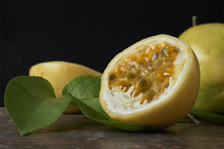 Fresh Yellow Passion Fruit with Leaves on Rustic Wooden Table