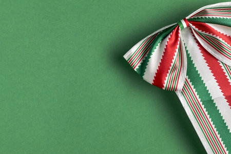 Festive Mexican ribbon in bright green, white, and red on a plain green background.