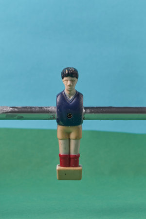 Foosball Player Figure Mounted on Rod With Colorful Background Scene