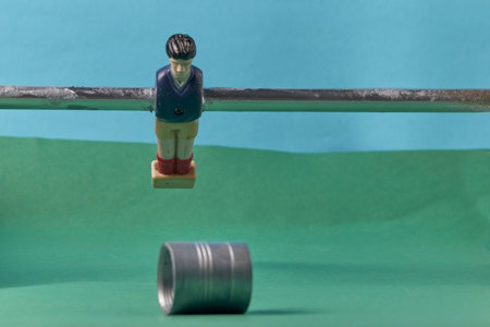 Foosball player figure mounted on rod about to hit objectの写真素材